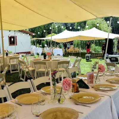 Decorațiuni romantice de masă cu flori și lumânări la o nuntă sub cort african în aer liber