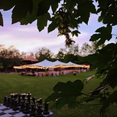 Nuntă în aer liber la apus sub un cort african decorat cu ghirlande luminoase